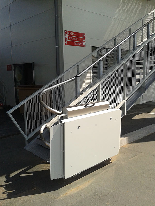 Pose d’une plateforme élévatrice oblique droite sur escalier permettant l’accès des personnes en fauteuils aux gradins
